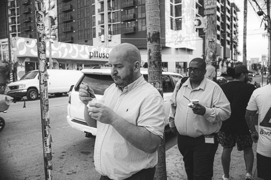 Reporter taking notes while interviewing a source outdoors